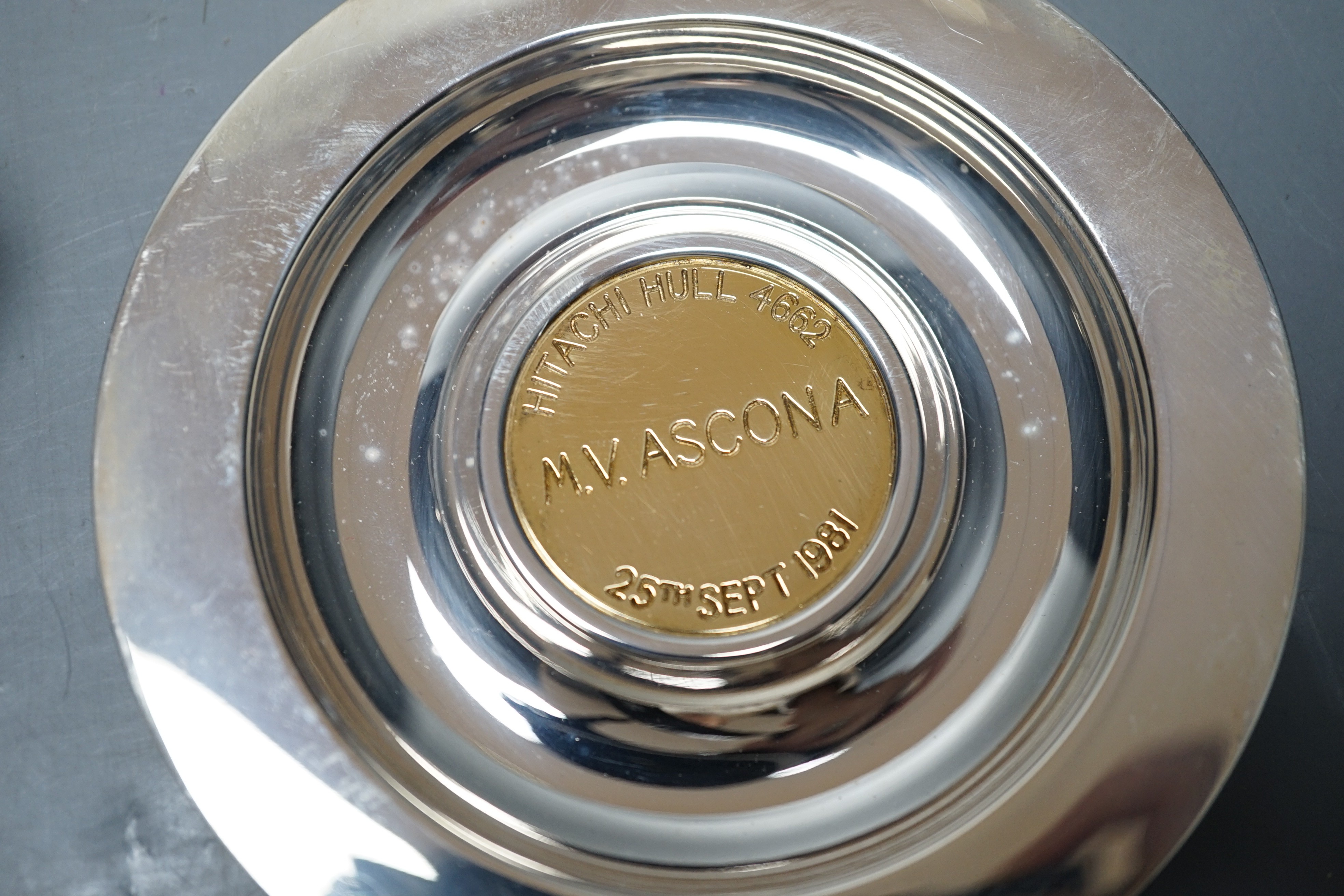A modern silver cigarette box, with turned wooden handle, Birmingham, 1955, 14.7cm and a modern silver Asprey dish, with engraved yellow metal central plaque, gross 8.6oz.